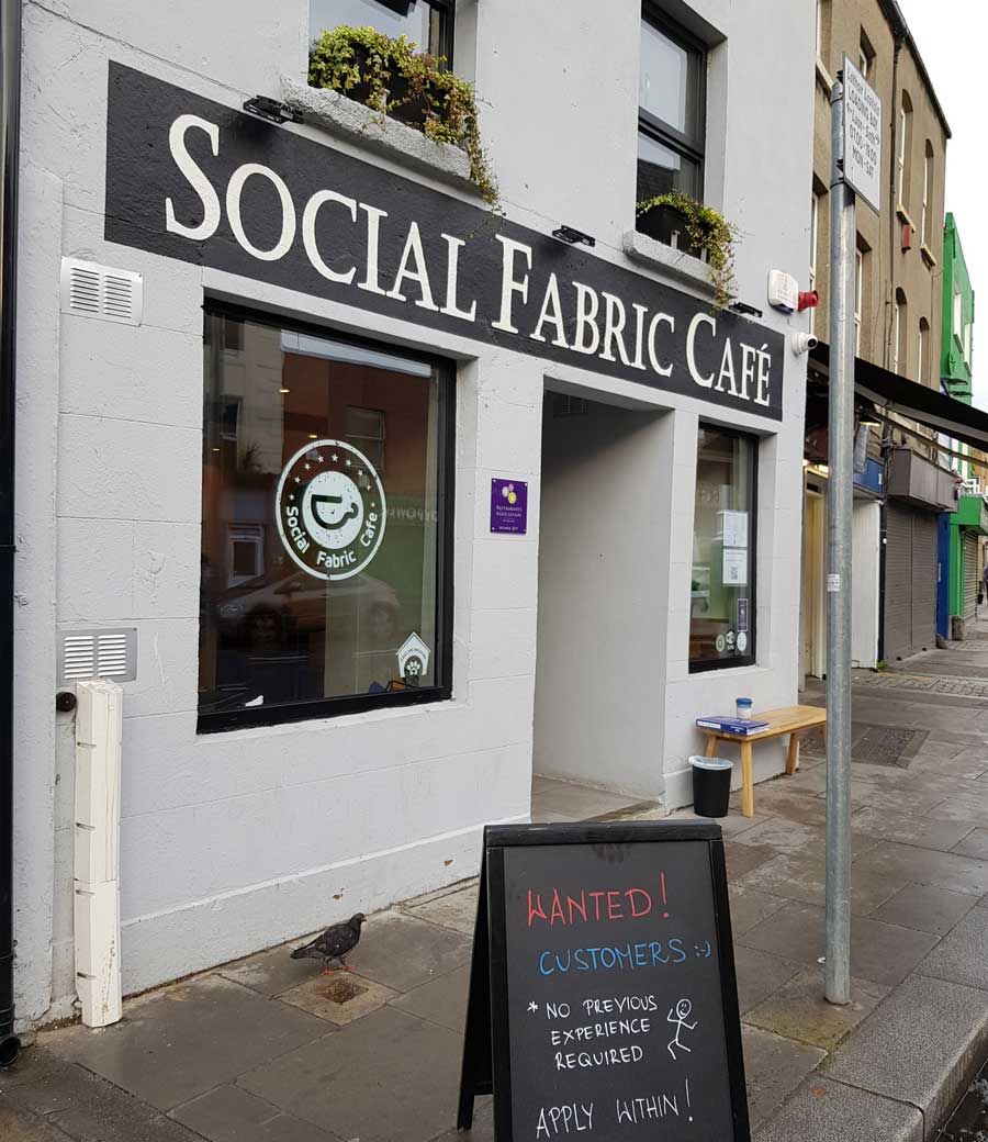 Exterior of Social Fabric Café with a sandwich board