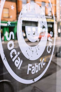 Close-up of the Social Fabric Café's logo on glass