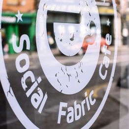 Close-up of the Social Fabric Café's logo on glass
